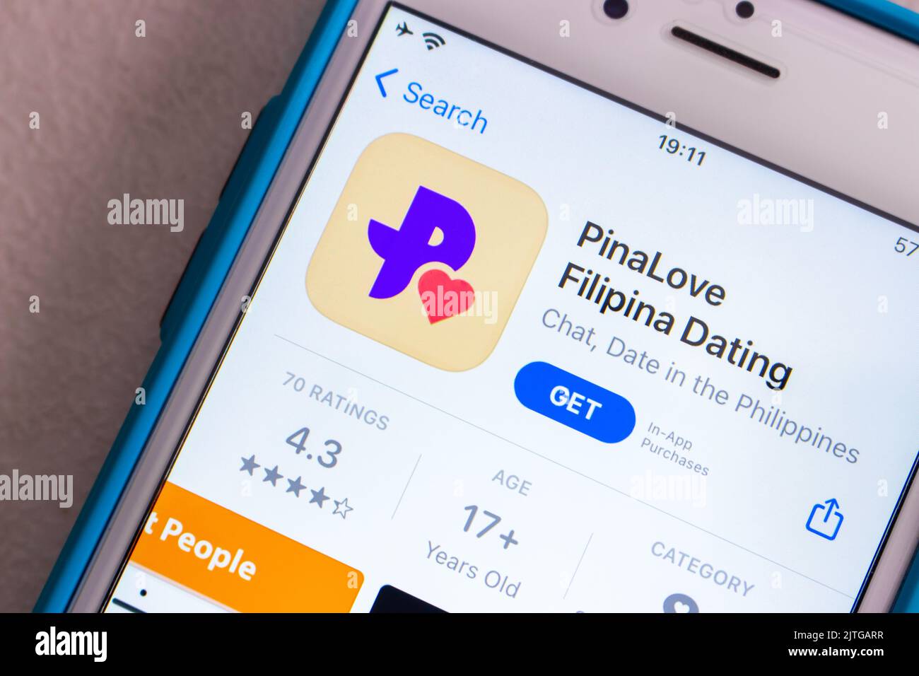 PinaLove app on App Store on iPhone on shabby chic table. It is free Filipina dating service allows users to find friends or love in the Philippines Stock Photo