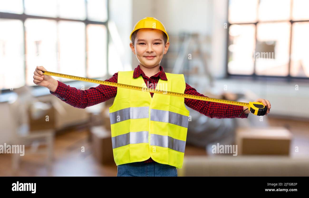 boy in construction helmet and vest with ruler Stock Photo Alamy