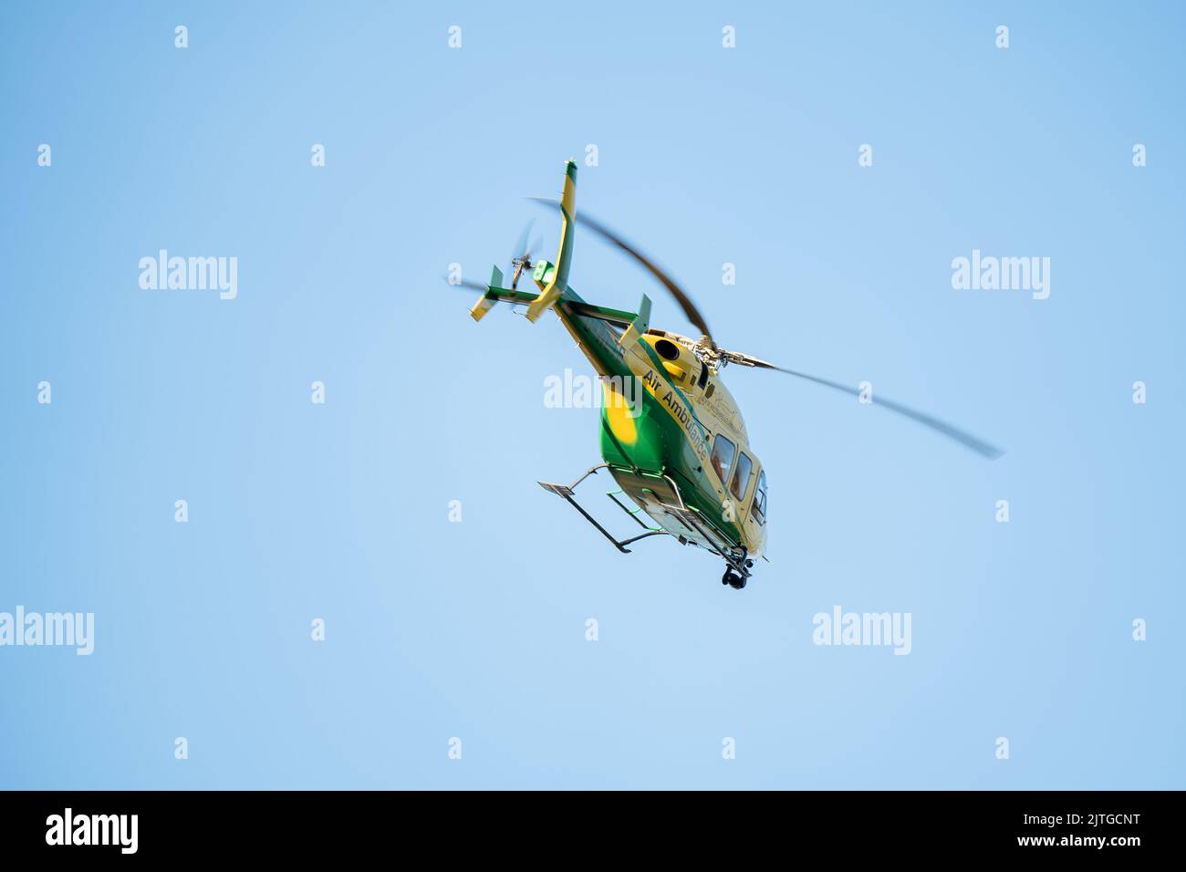 Wiltshire Air Ambulance in flight, clear blue sky Stock Photo