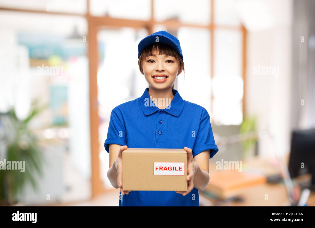 happy delivery woman holding parcel box at office Stock Photo - Alamy