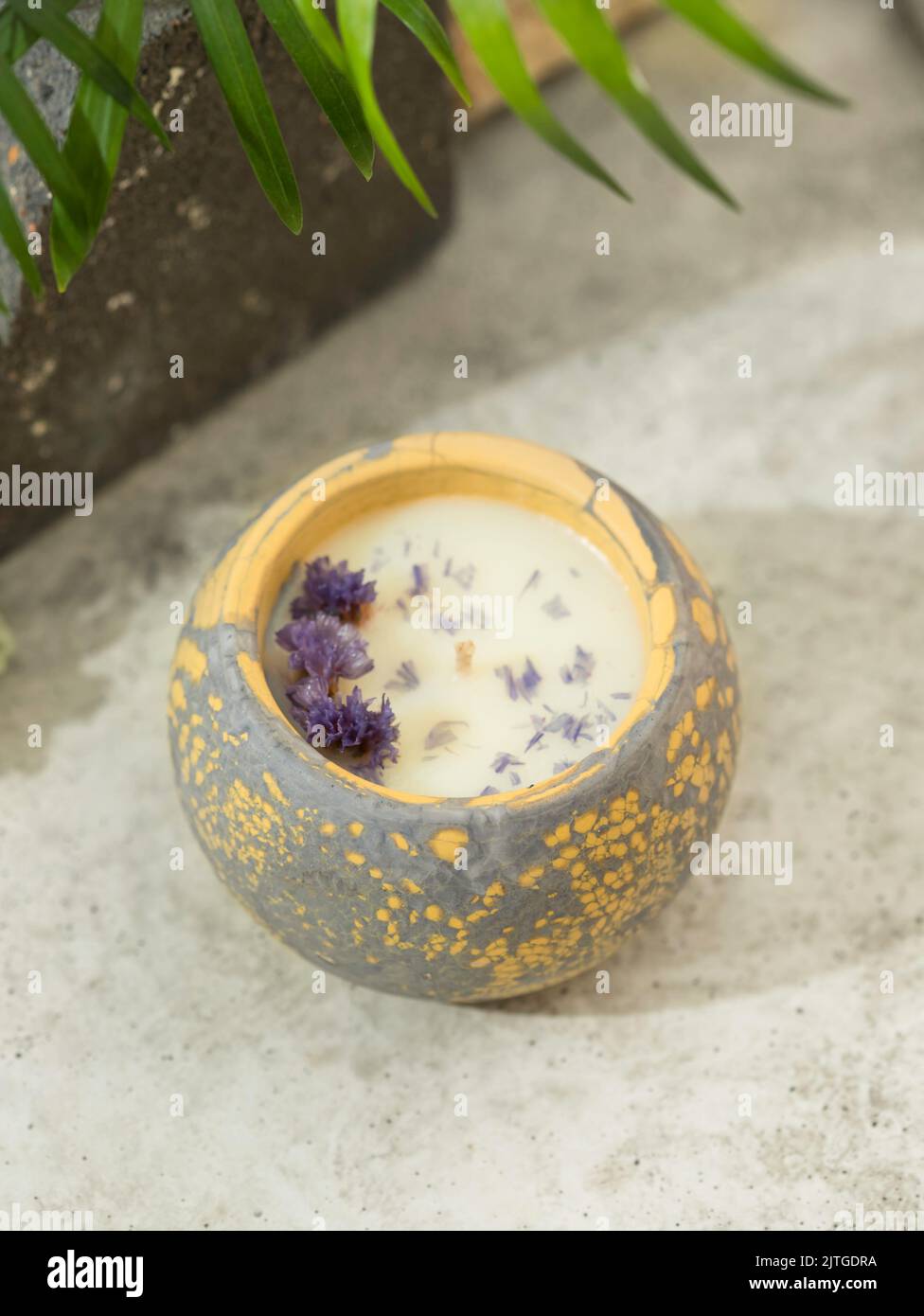 Soy candle in a concrete, plaster candlestick, decor interior. Home decoration with a burning scented candle. Gypsum, concrete products. Copy space fo Stock Photo
