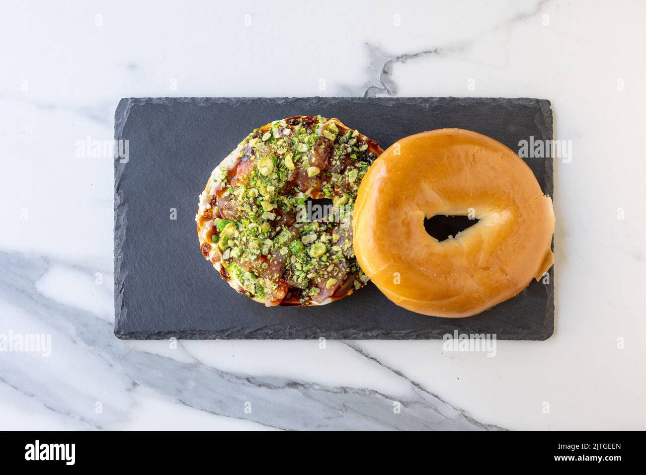 A top view of an open cut bagel with delicious meat, vegetables, and