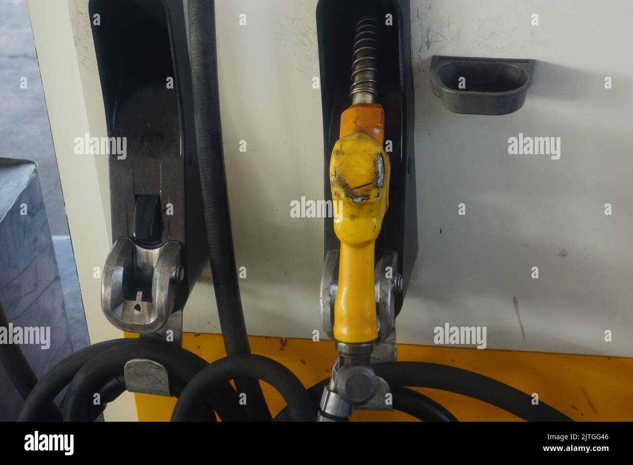 A yellow gas pump nozzle in a service station Stock Photo Alamy
