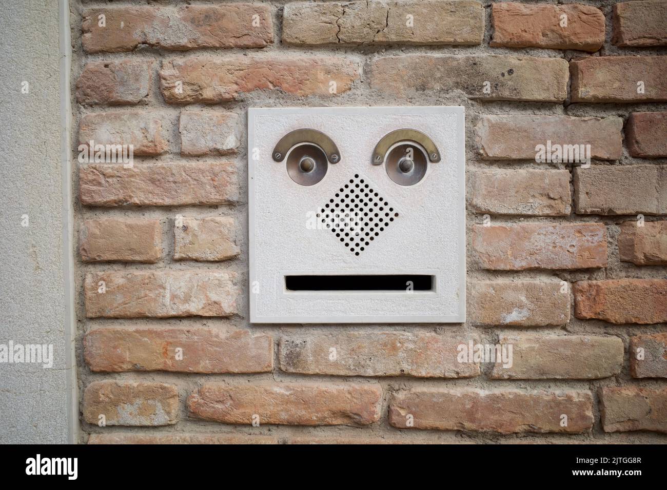 Common door bells in Venice, Italy. The design makes it look like a face with eyes, eyebrows, nose, and mouth. Stock Photo