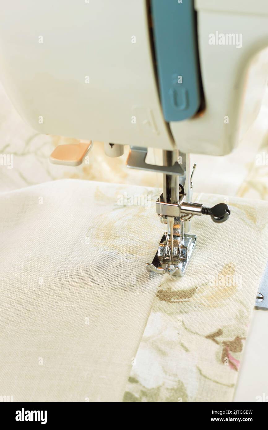 Modern sewing machine presser foot and colofrul cloth. Sewing process