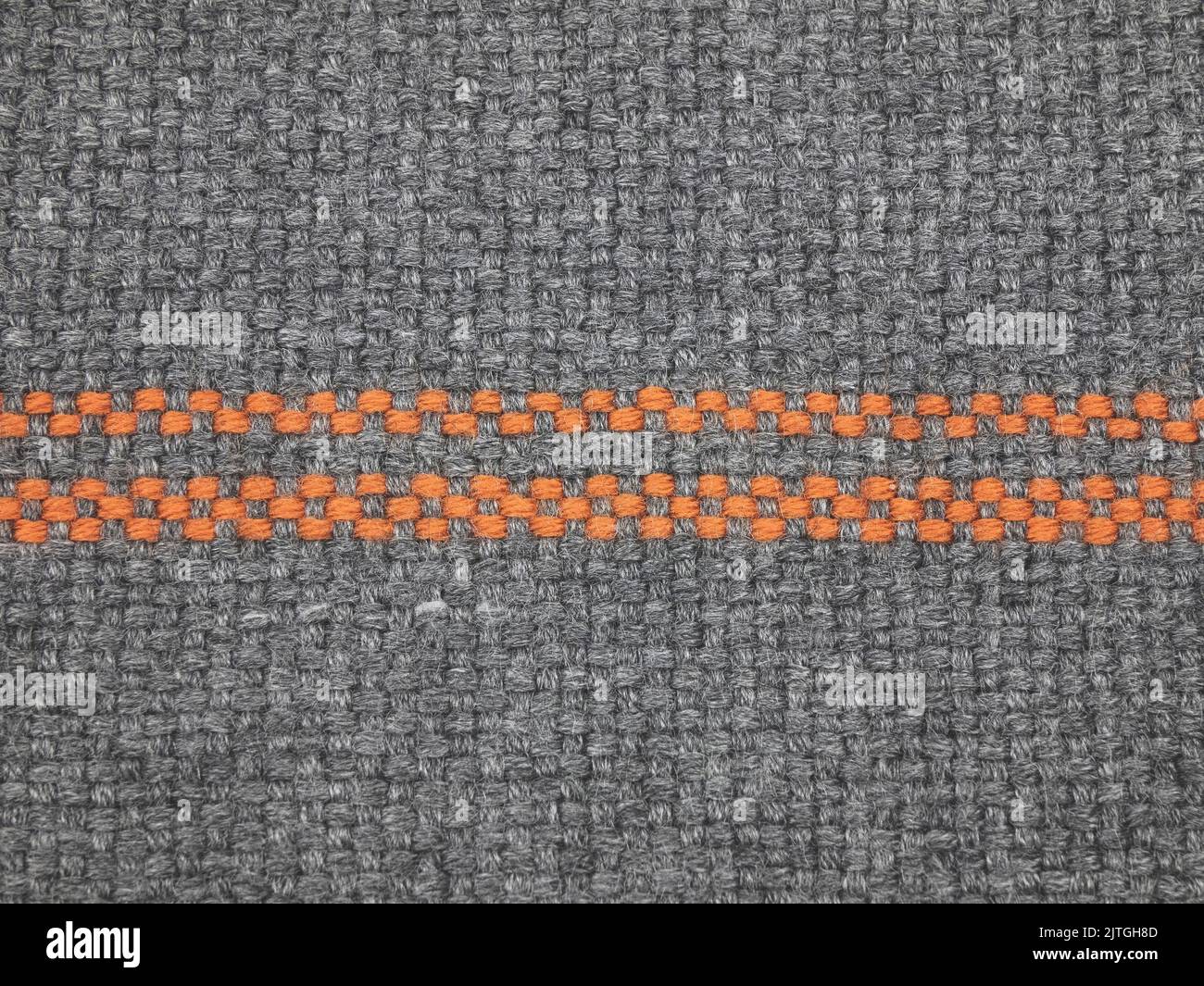 Texture of knitted fabric. Pattern of interwoven threads. Gray and orange textile material, close up Stock Photo