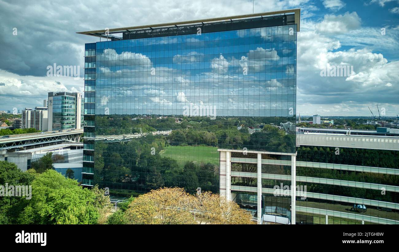 GSK London HQ reflecting sky and clouds in building's mirror facade Stock Photo