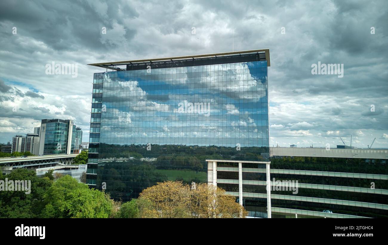 GSK London HQ reflecting sky and clouds in building's mirror facade Stock Photo