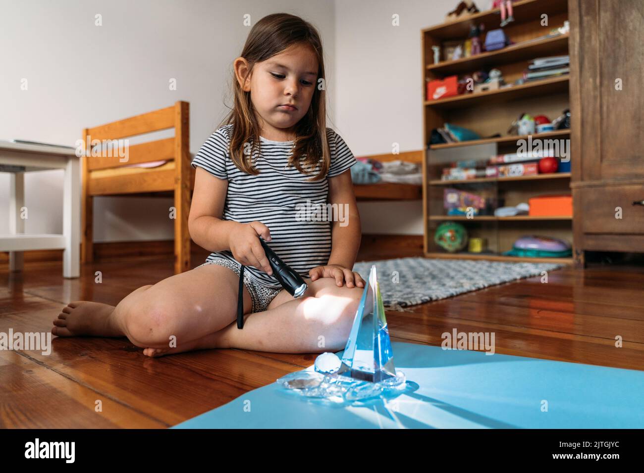 Child girl playing with crystals and torch light, learning about ...