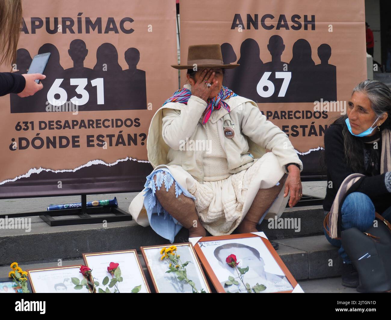 Peru, 30/08/2022, An indigenous woman cries next to the photo of a missing person when nineteen years after the presentation of the final report of the Truth and Reconciliation Commission (CVR), relatives of the victims of terrorism in Peru (1980 - 2000) took to the streets carrying photos and lists with the names of their missing relatives, demanding reparation from the state. The Truth Commission was a Peruvian organism mainly responsible for preparing a report on the Era of Terrorism in Peru, which indicates that there were more than 70,000 victims and some 20,000 disappeared as a result of Stock Photo