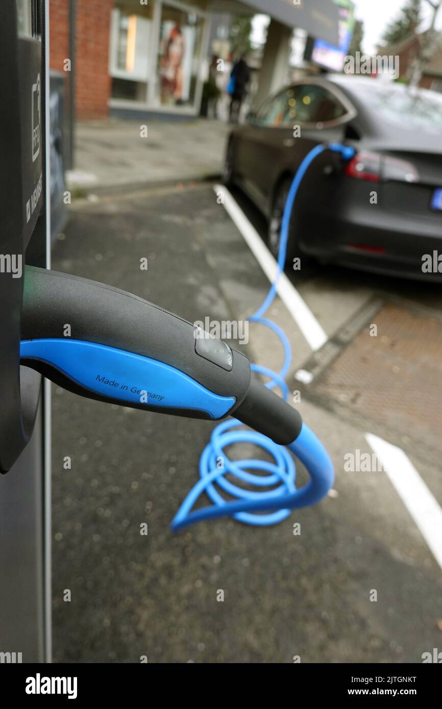 Car at a charging station with blue charge cable, Germany, North Rhine-Westphalia, Cologne Stock Photo