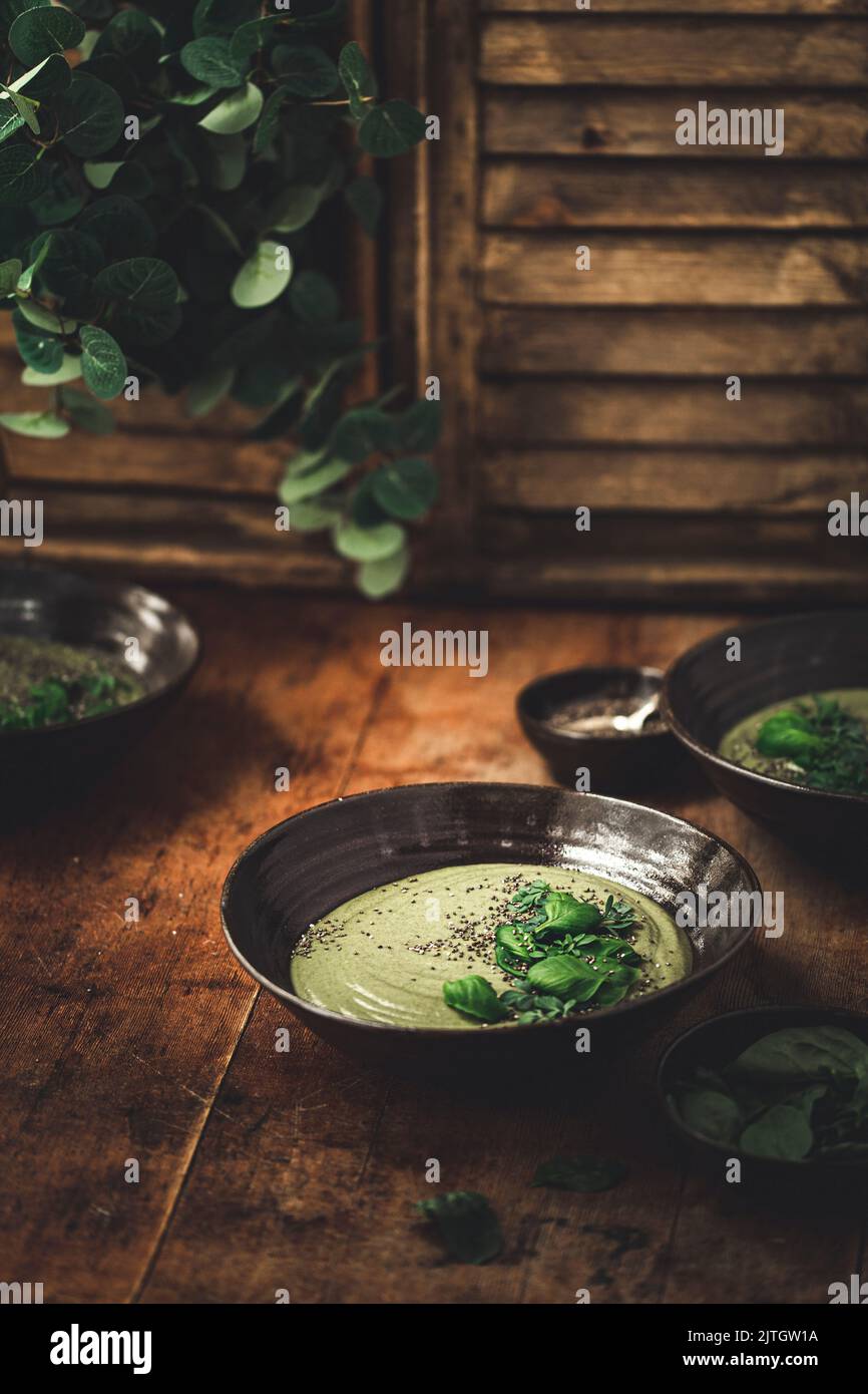 Cream Green Pea soup in a black bowl Stock Photo
