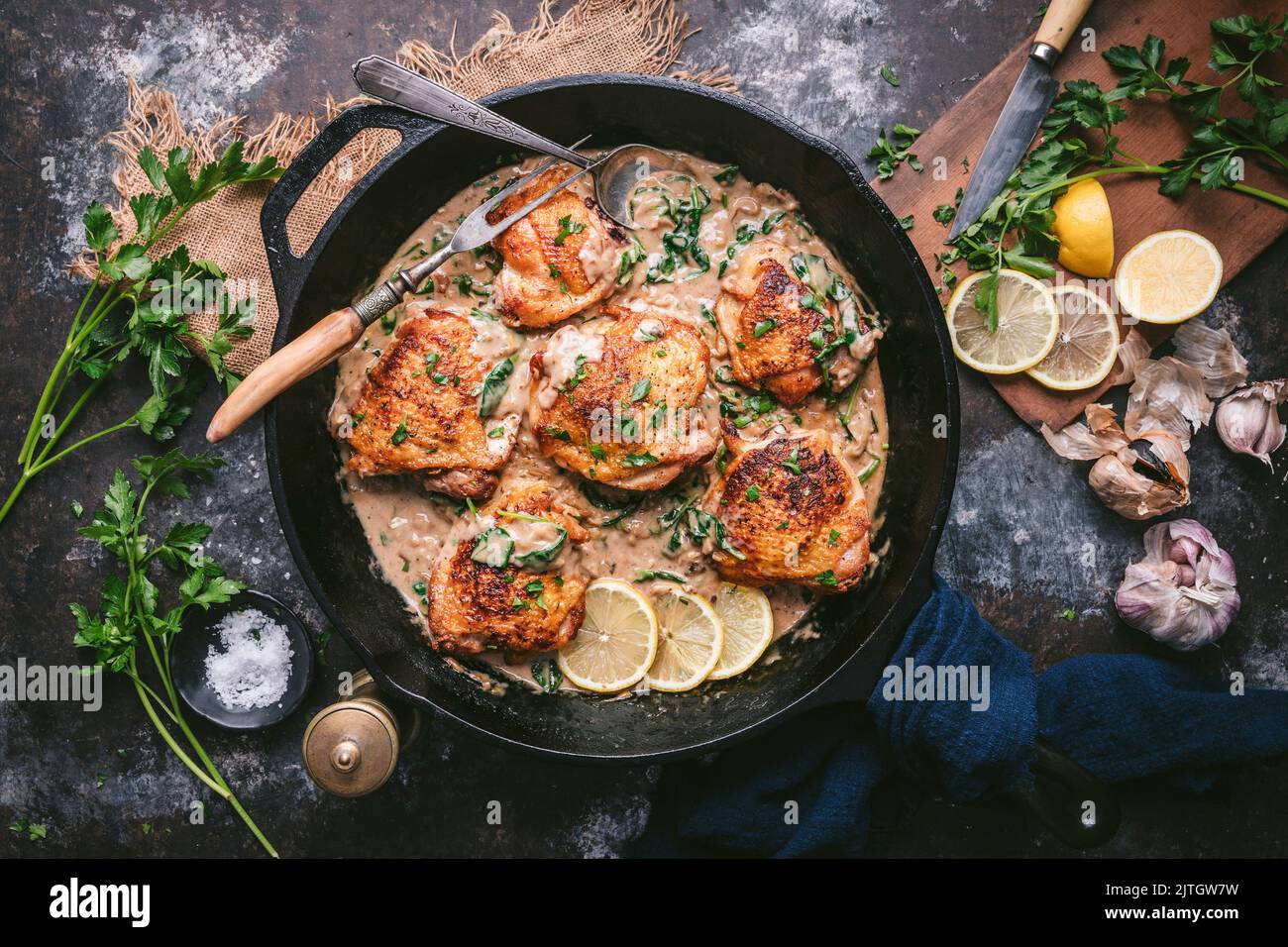 Crispy chicken thighs in creamy lemon sauce in cast iron skillet with