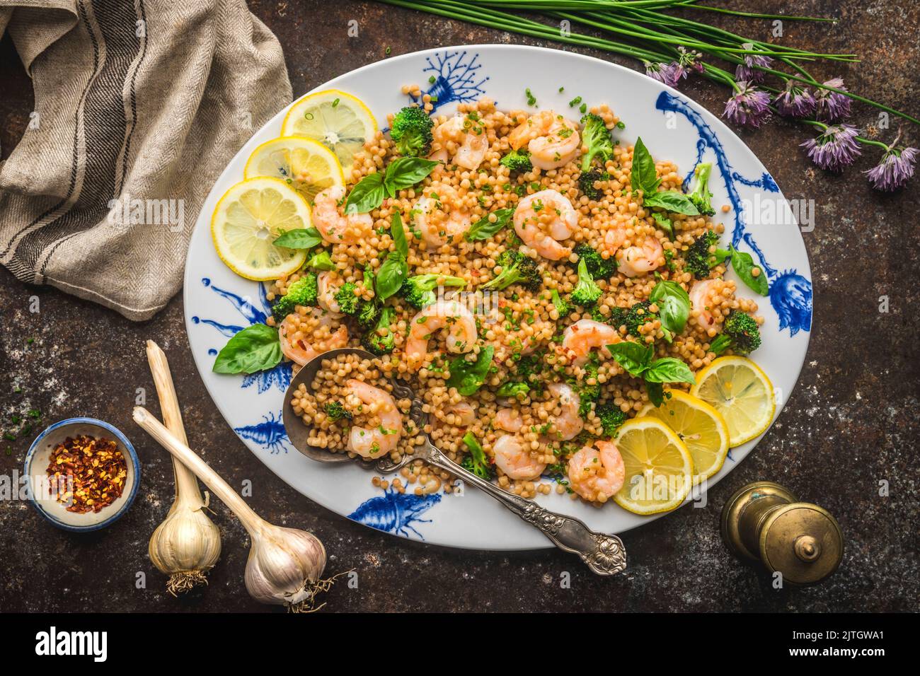 Shrimp with Pearl Couscous and Broccoli on Platter with Chives and Garlic Stock Photo