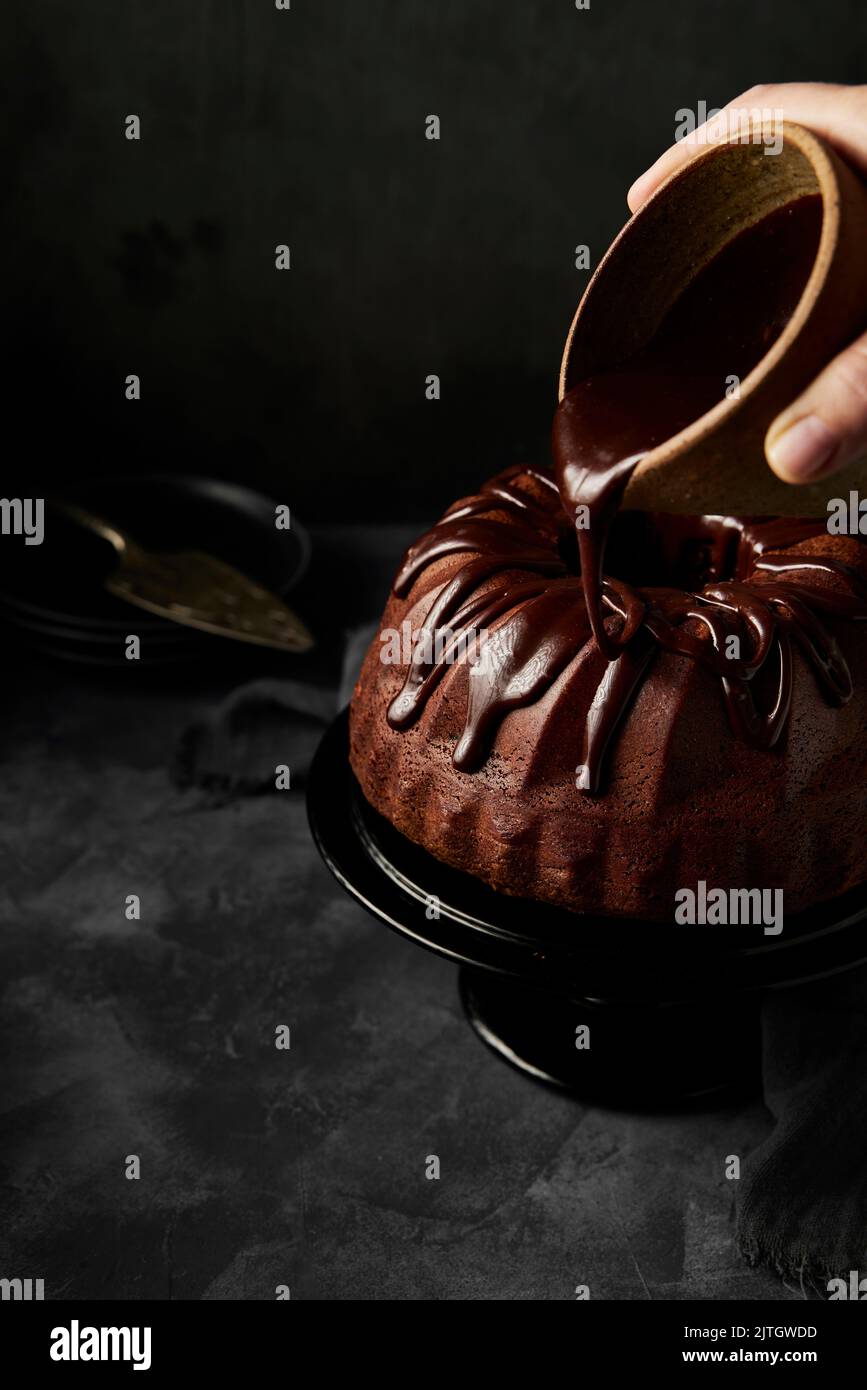 Chocolate & Ganache Drizzle Bundt Cake on dark background Stock Photo