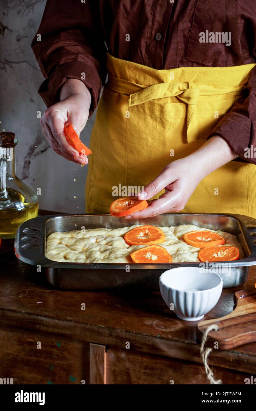 Sweet Focaccia with oranges,  woman preparing process Stock Photo