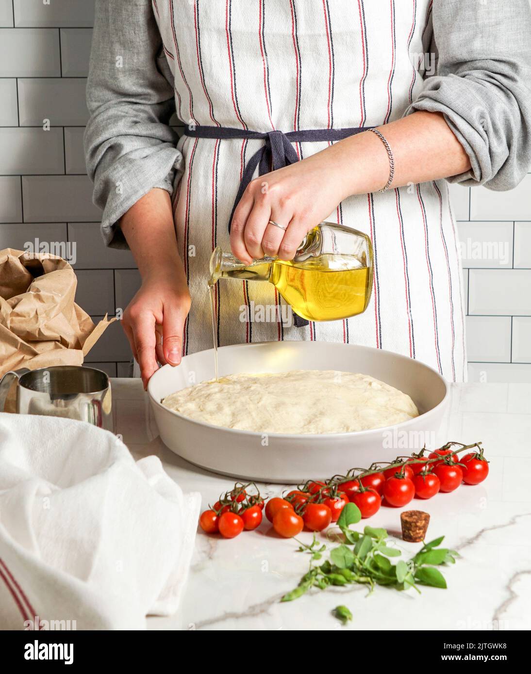 Italian Focaccia with cherry tomatoes, woman preparing process Stock ...