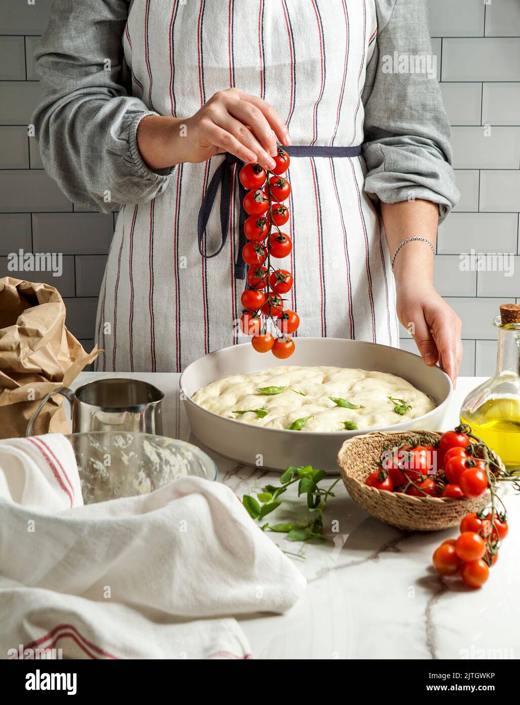 Italian Focaccia with cherry tomatoes, woman preparing process Stock ...