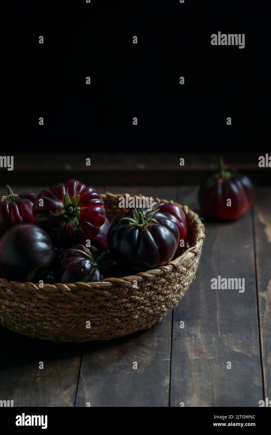 purple violet tomatoes in a wicker basket Stock Photo