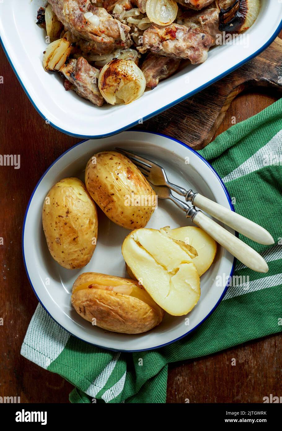 pork ribs baked in the oven with onions, baked jacket potatoes, rural