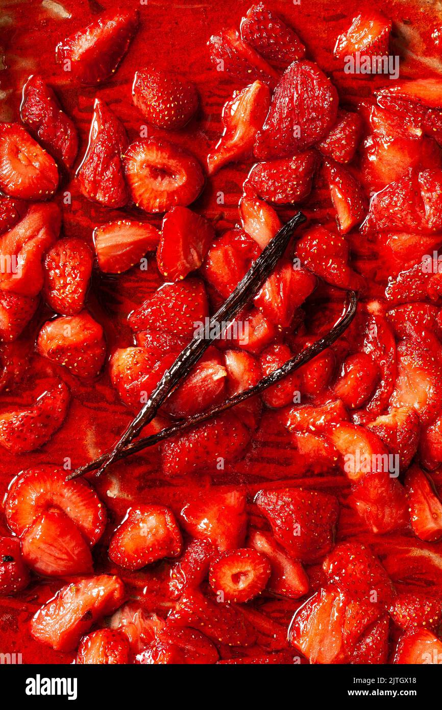 Roasted strawberries with a split vanilla pod to make strawberry sauce. Stock Photo