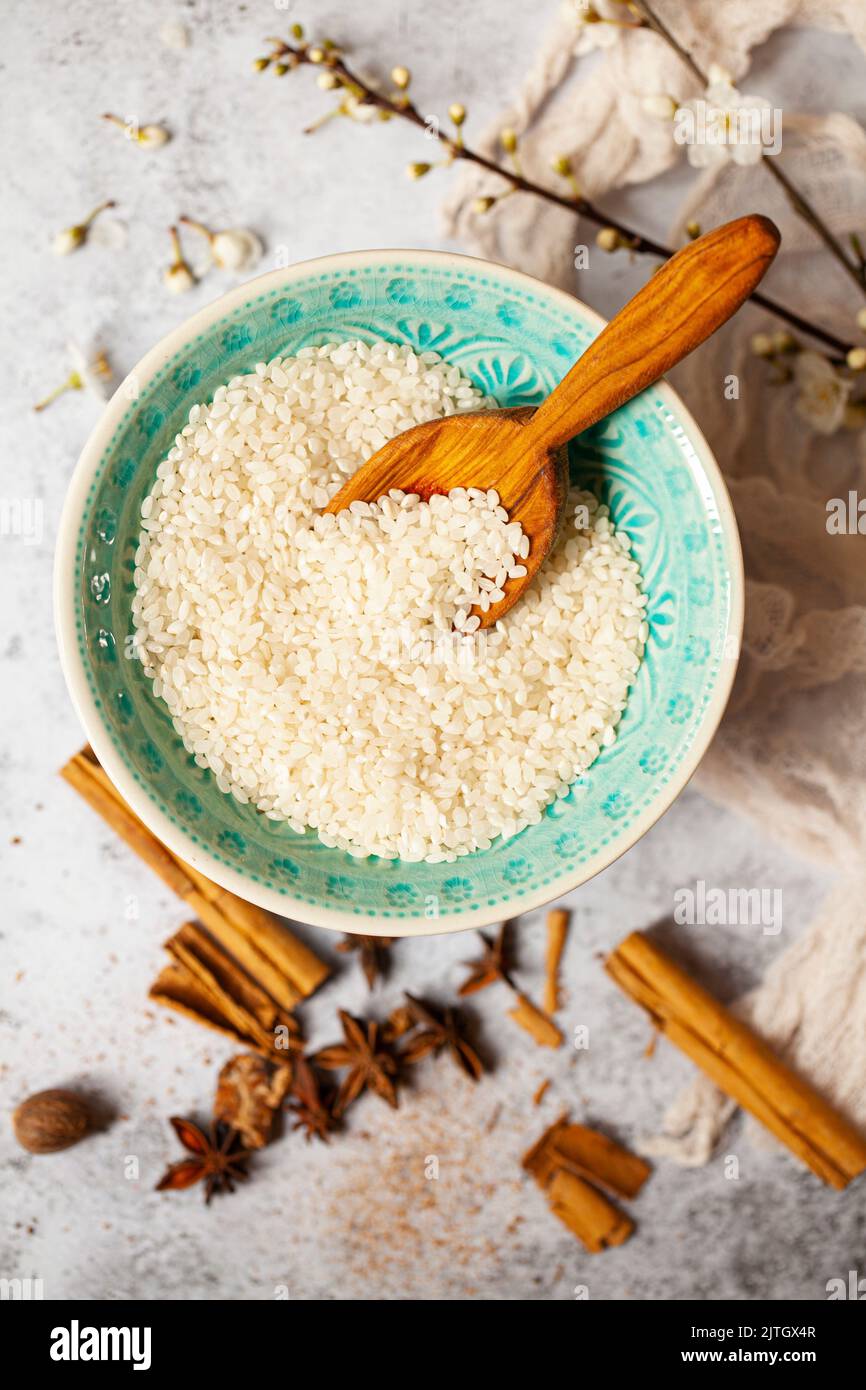 A bowl of short grain pudding rice with baking spices alongside. Stock Photo