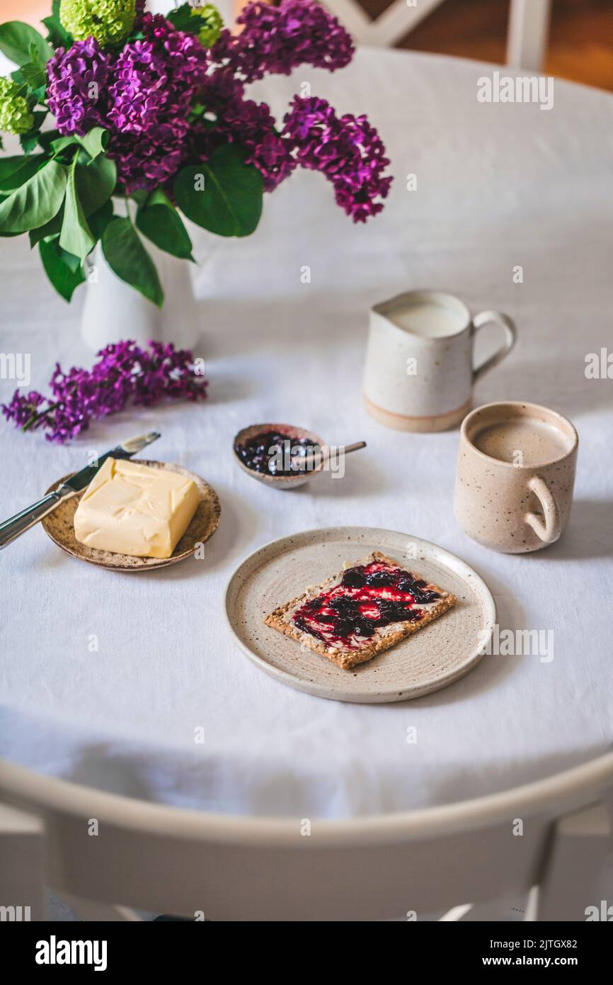 Crispbread with butter and jam and coffee with milk served for breakfast Stock Photo