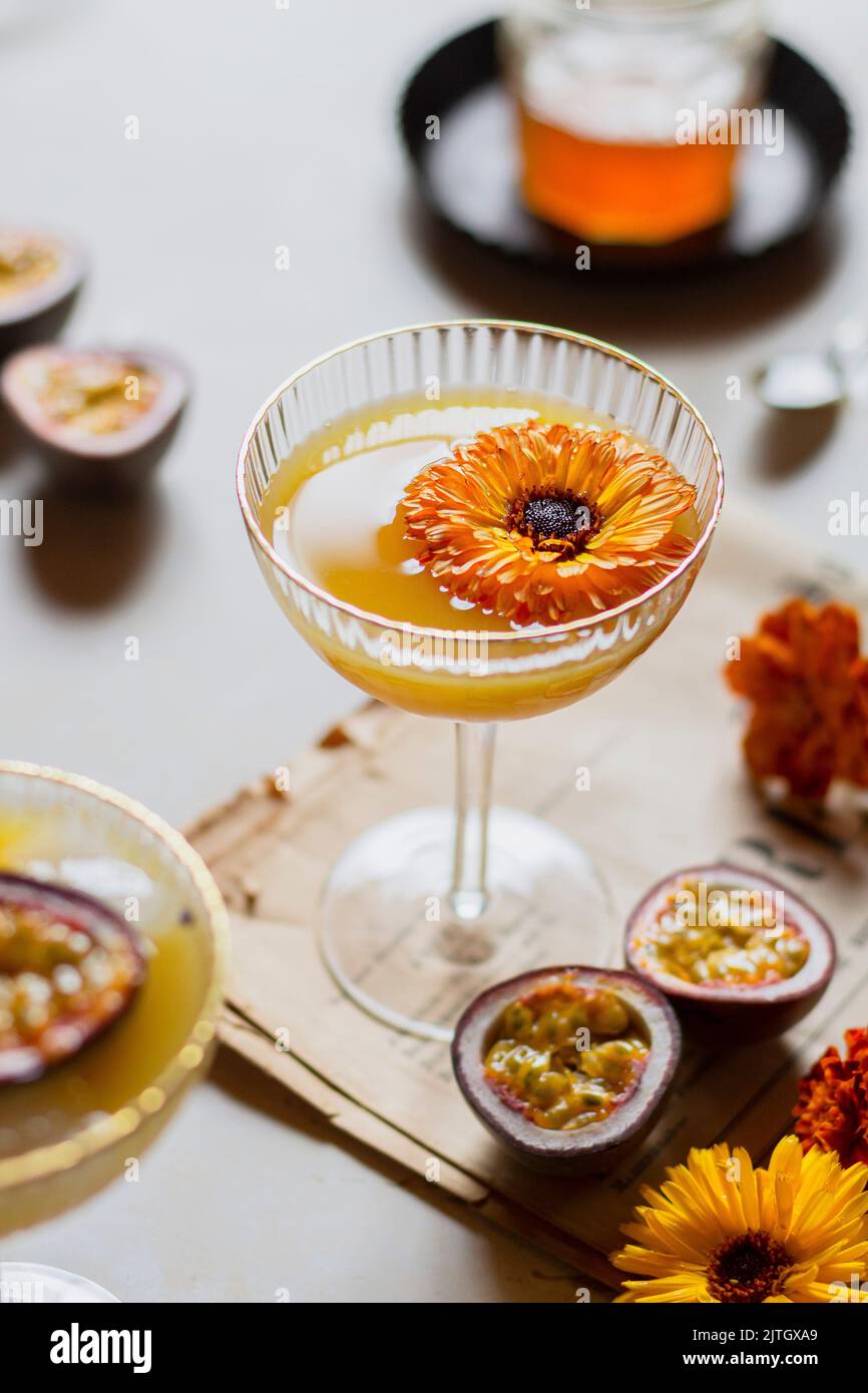 Passion fruit martini with edible flower in a coupe glass Stock Photo