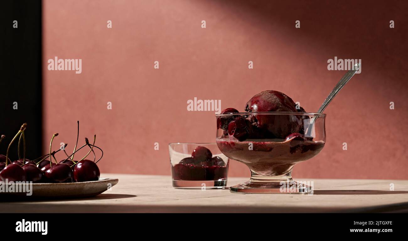 A bowl of chocolate gelato with wine poached cherries. Stock Photo