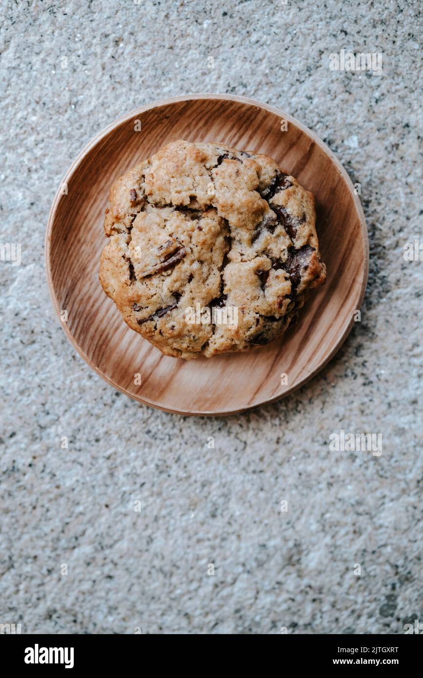 a cookie on a small wooden plate, on a grey textured background Stock Photo