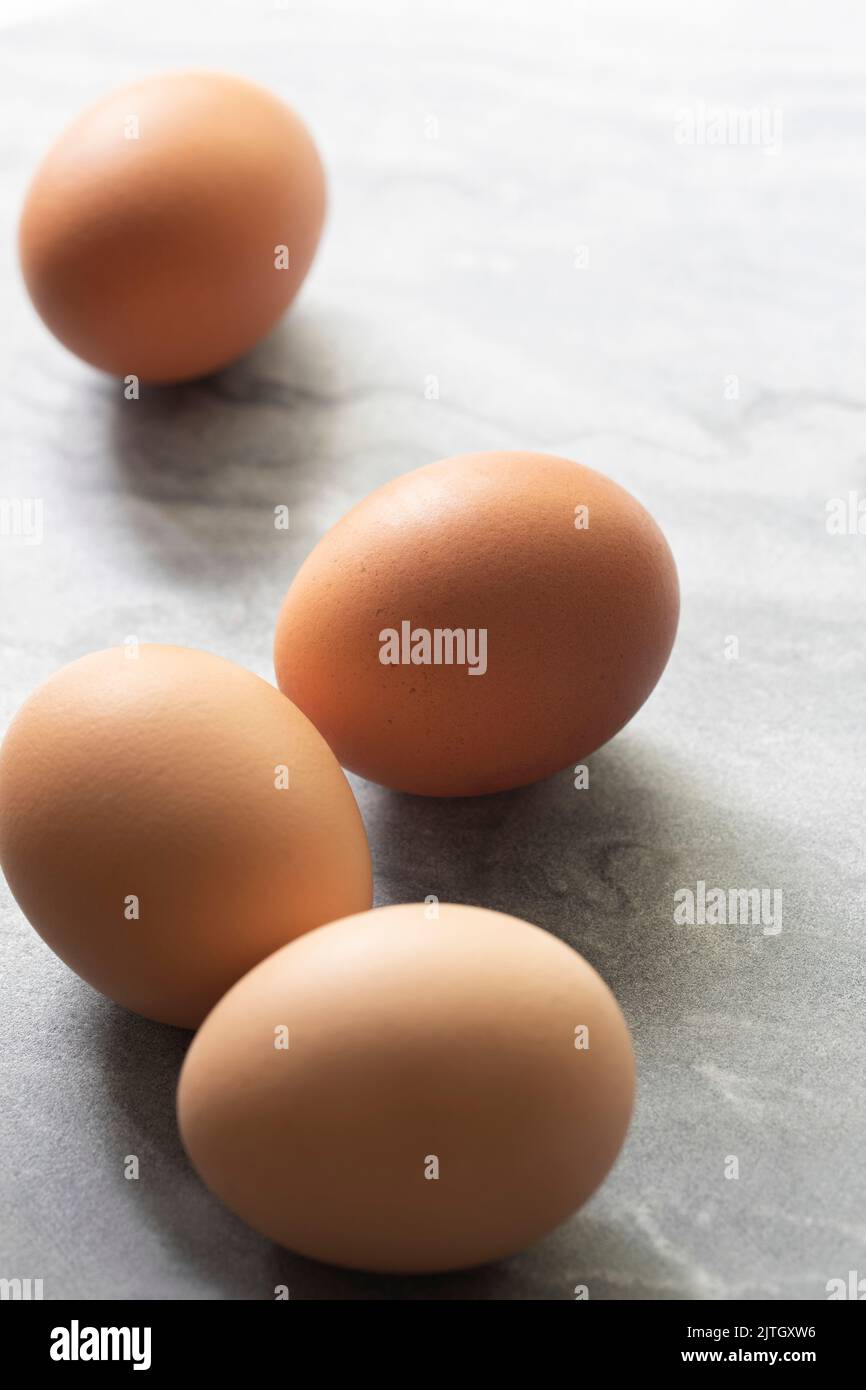 Four brown chicken eggs on a marble benchtop. Stock Photo