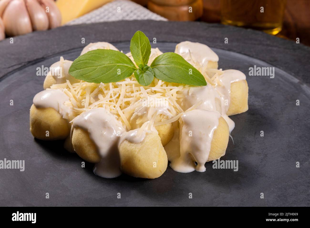 Potato gnocchi in white sauce with grated Parmesan cheese and basil