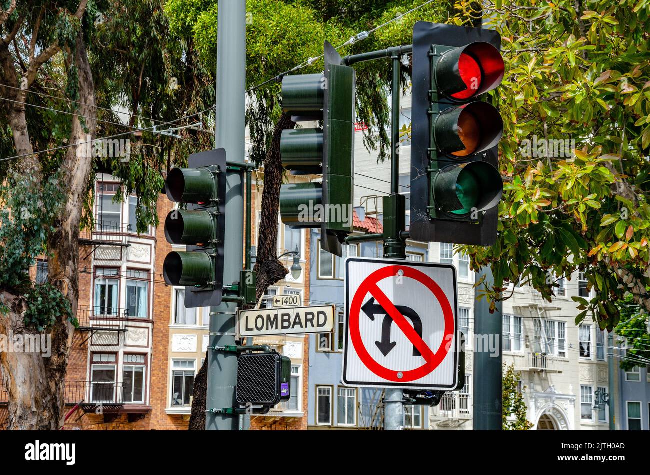 A street sign at a set of traffic lights on Lombard Street in San Francisco, California stating that there is no left turn or u-turn allowed Stock Photo