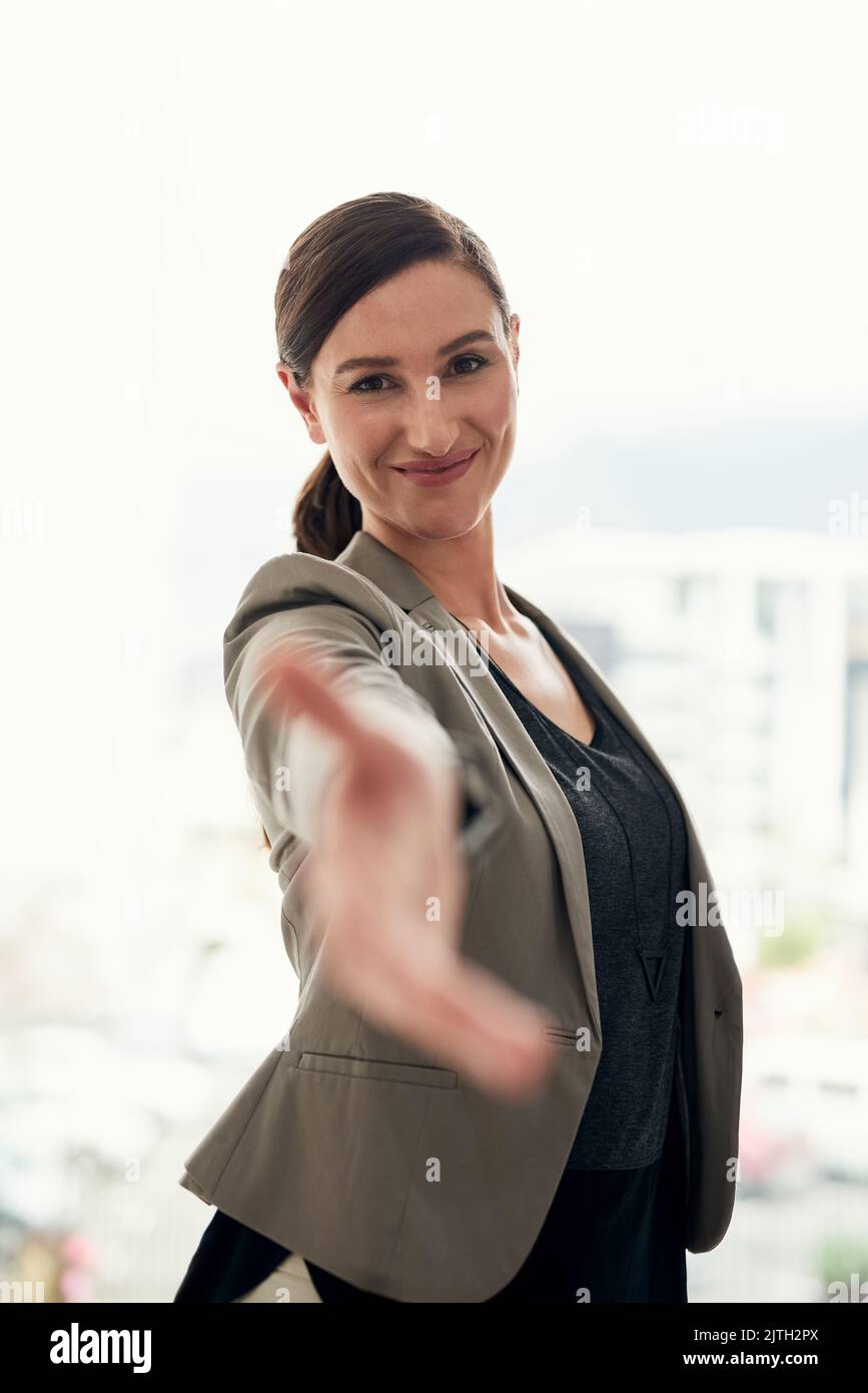 Lets journey on to success. Portrait of a young businesswoman extending her arm for a handshake. Stock Photo