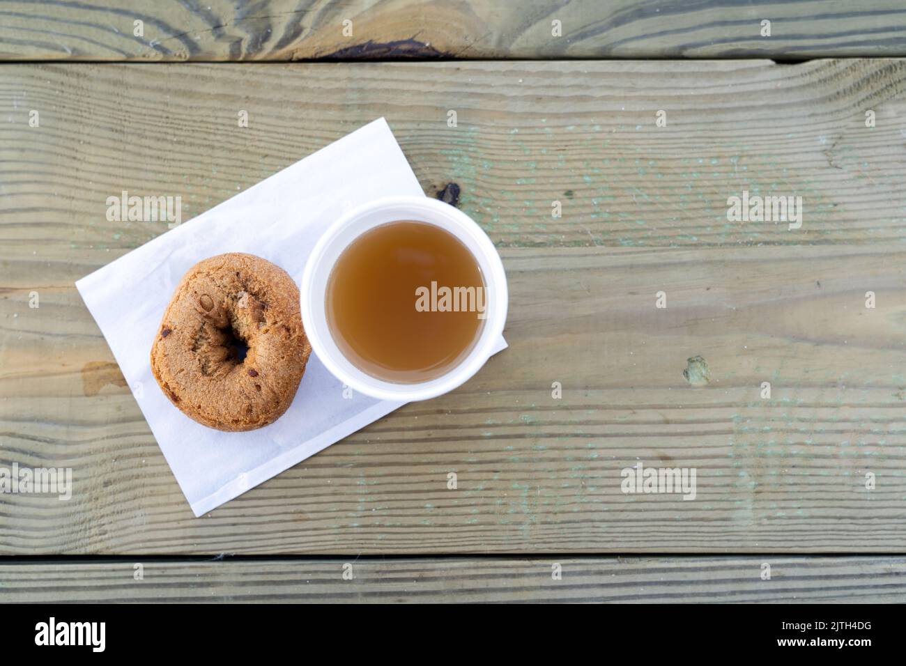 Cup of apple cider and a cinnamon donut Stock Photo