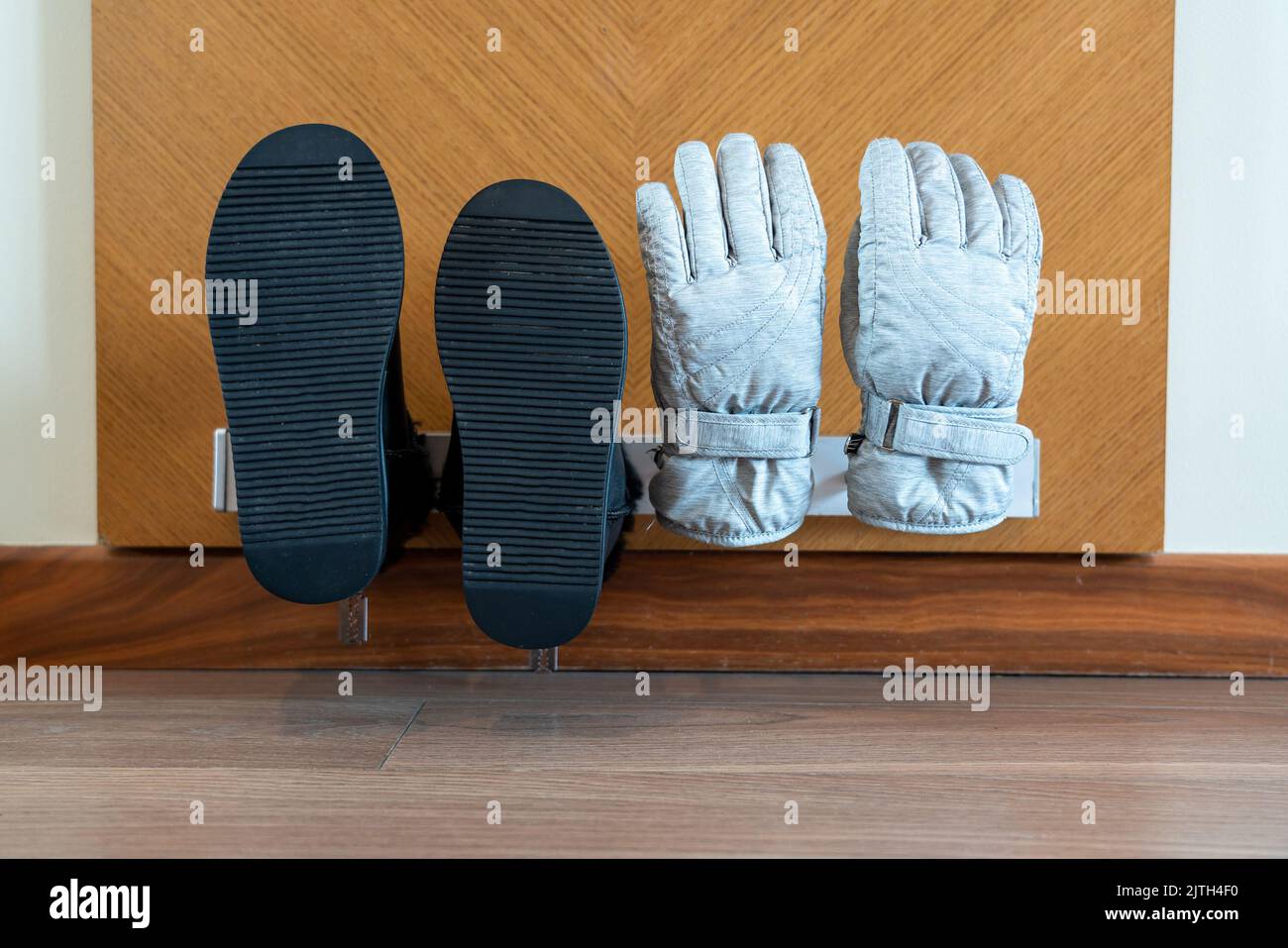 Wallmounted electric dryer with shoes and gloves put on it in a hotel