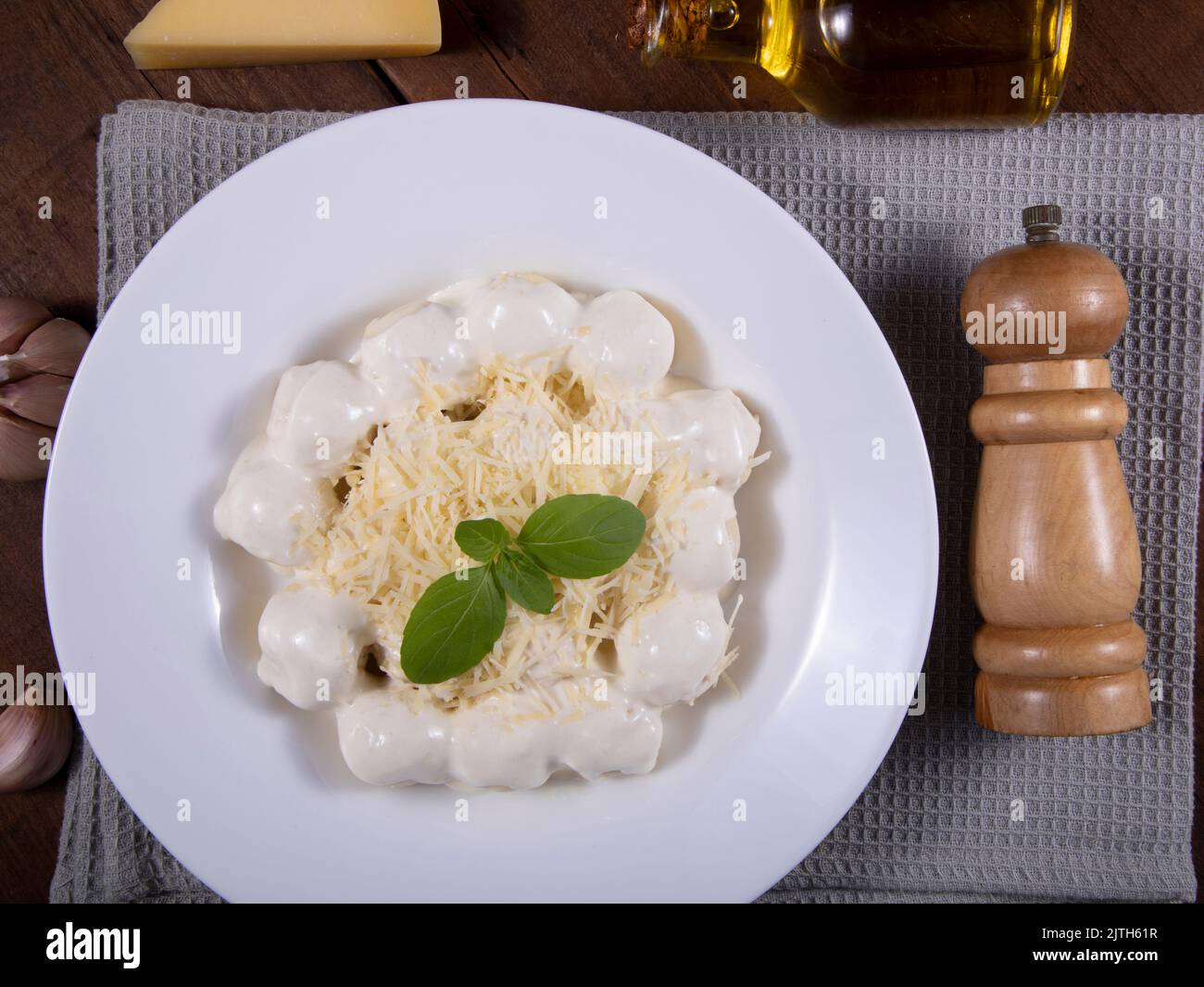 Potato gnocchi in white sauce with grated Parmesan cheese and basil