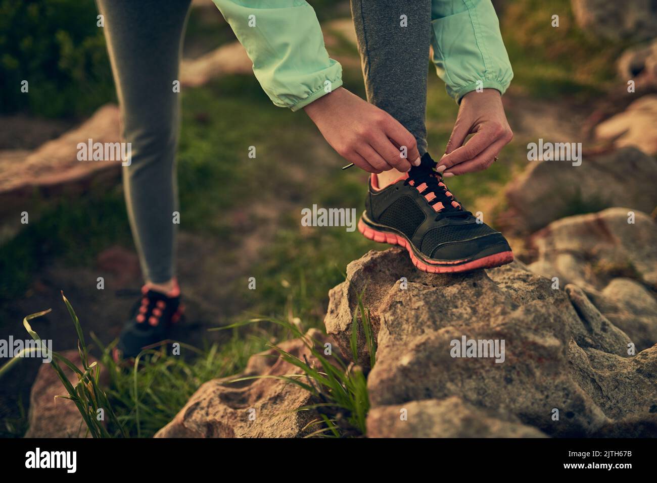 Making sure her shoes are secure. an unrecognizable woman tying her shoe laces before a run. Stock Photo