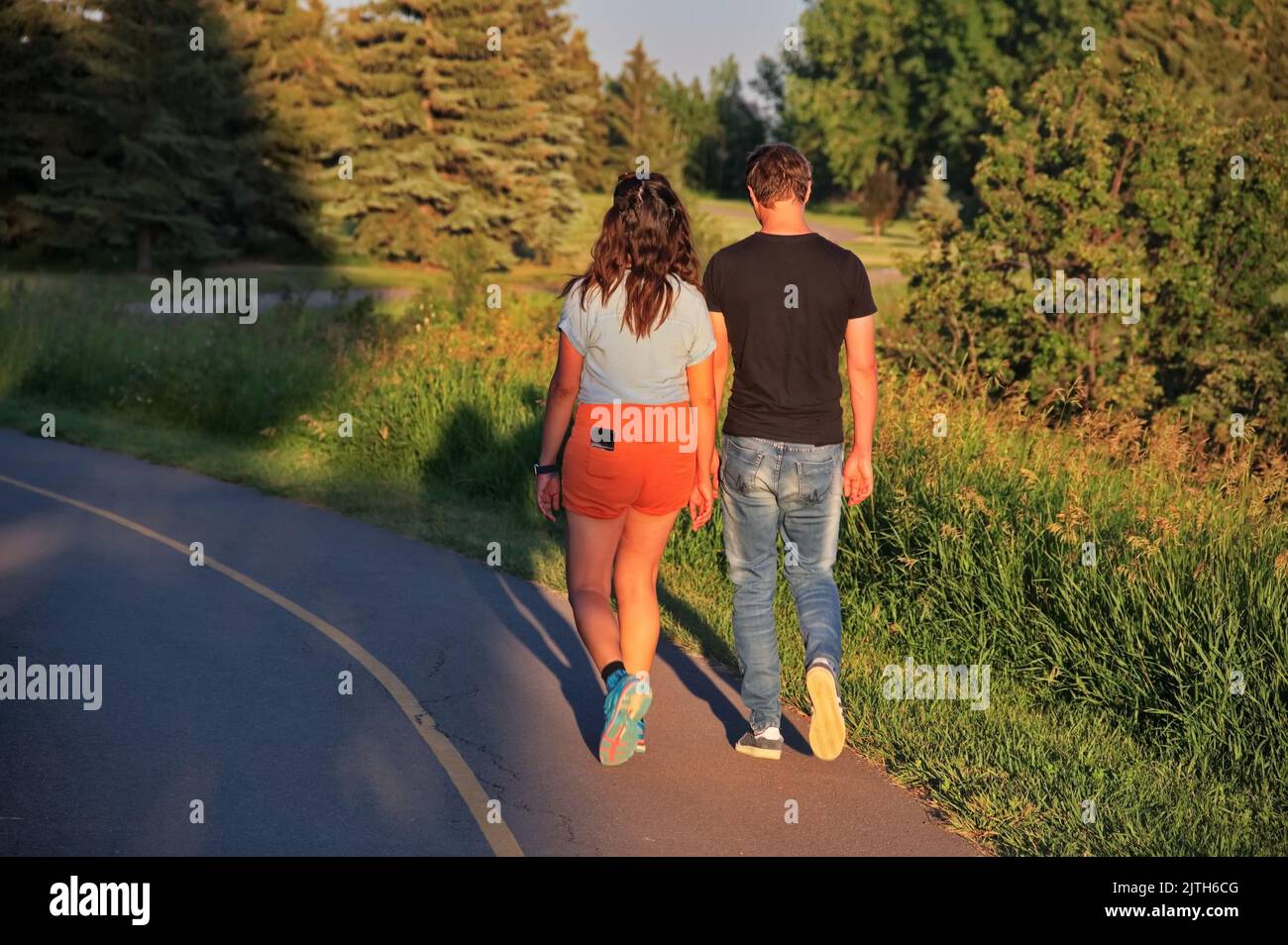 Mature couple walking in sunset on the road Stock Photo