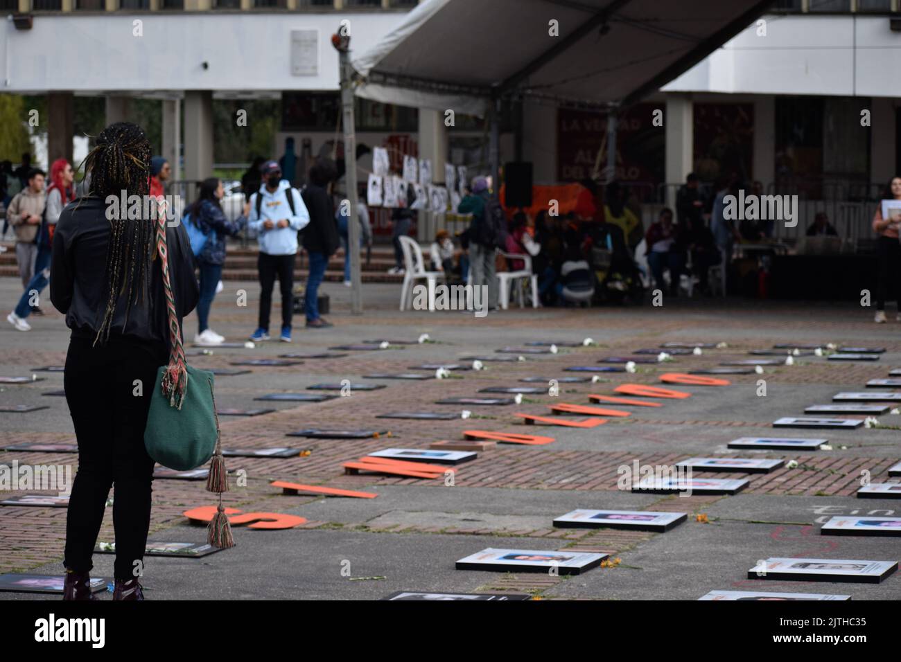 Bogota, Colombia, August 30, 2022. People walk by photos of victims of enforced disapearances are seen with the word phrase 'Never Forgotten' during the framework of the International Day of the Victims of Enforced Disappearances in Bogota, Colombia, August 30, 2022. According to Colombia's Victims unit more than 130.000 people had been indirect victims of Enforced Disappearances in Colombia and at least 50.000 had been direct victims of this crime. Photo by: Cristian Bayona/Long Visual Press Stock Photo