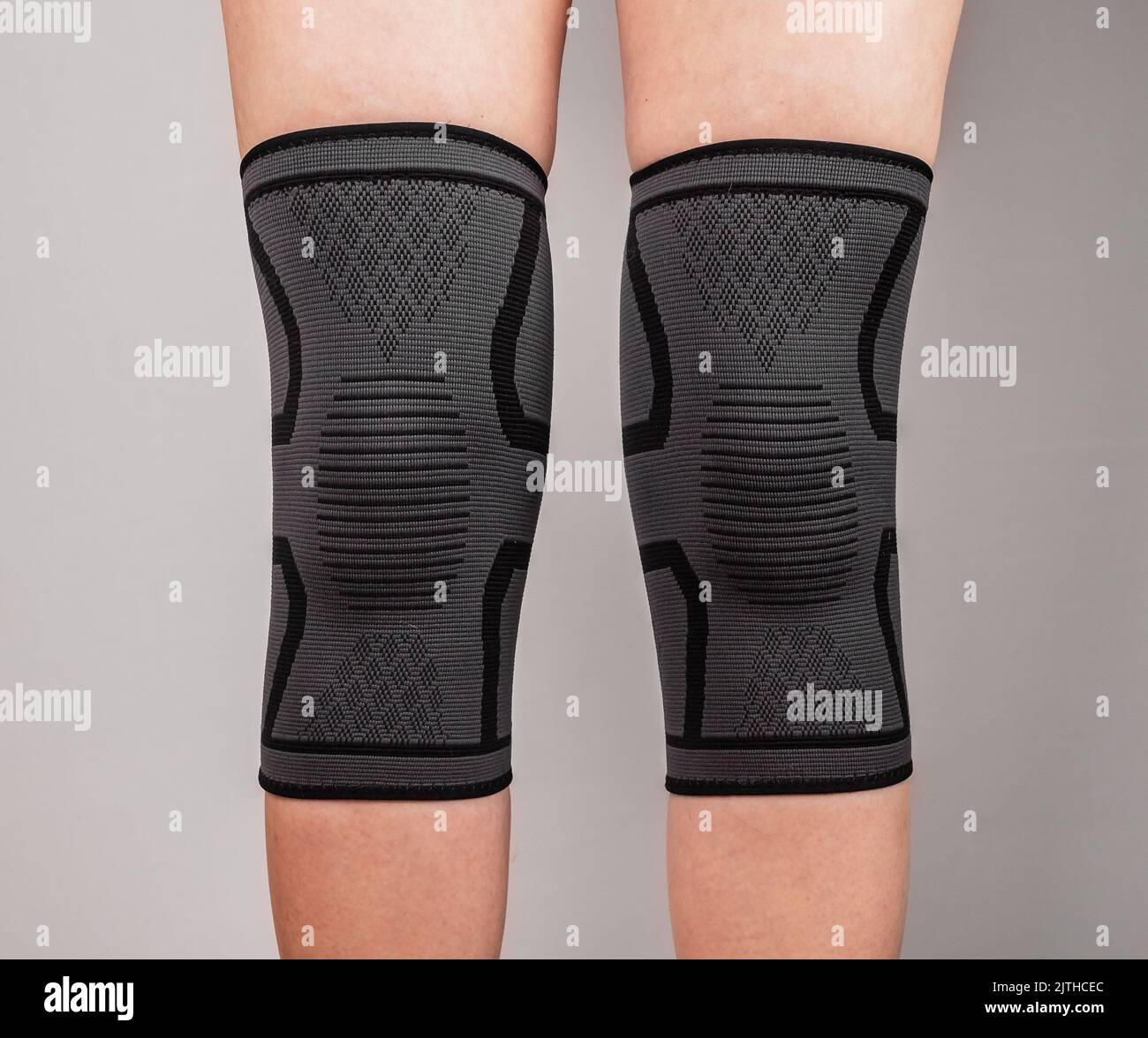 Woman legs in knee pads to relieve pain or discomfort, to prevent muscle, ligament strain, fracture. Patella braces. Health care concept High quality Stock Photo