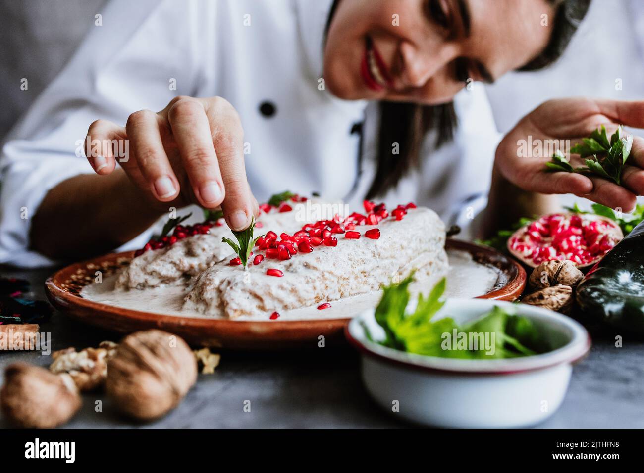cooking mexican chiles en nogada recipe by woman chef hands with