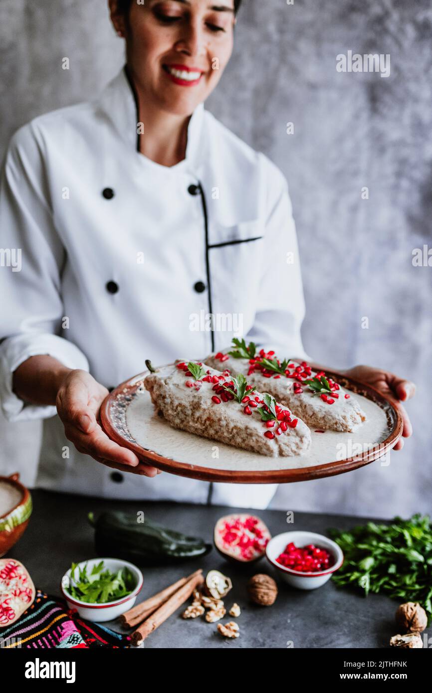 cooking mexican chiles en nogada recipe by woman chef hands with