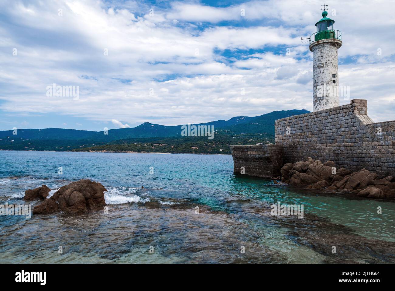 White lighthouse tower is on the pier. Entrance to Propriano port, Corsica island, France Stock Photo