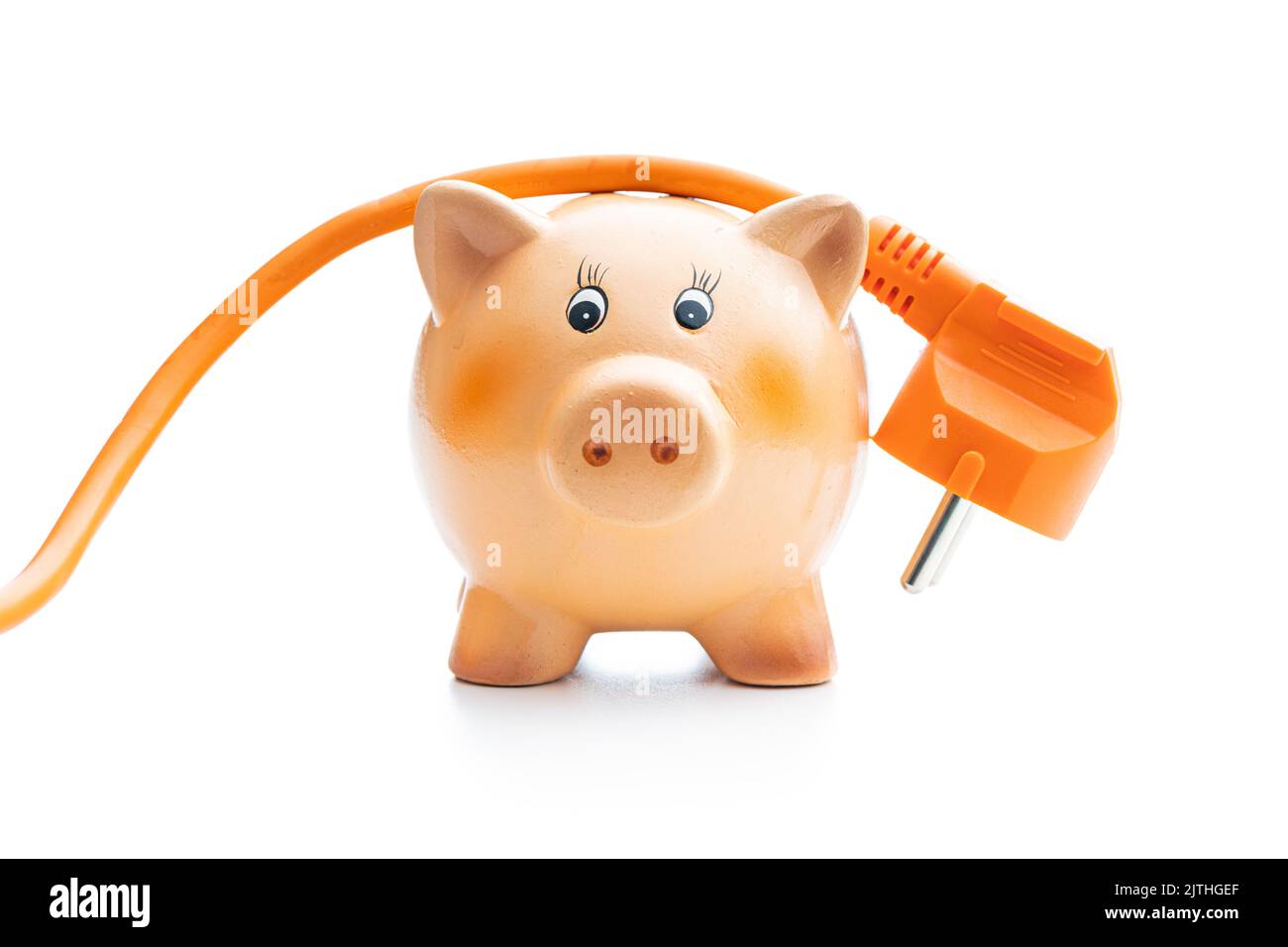 Orange extension Power Cord and piggy bank isolated on white background. Concept of increasing electricity prices. Stock Photo