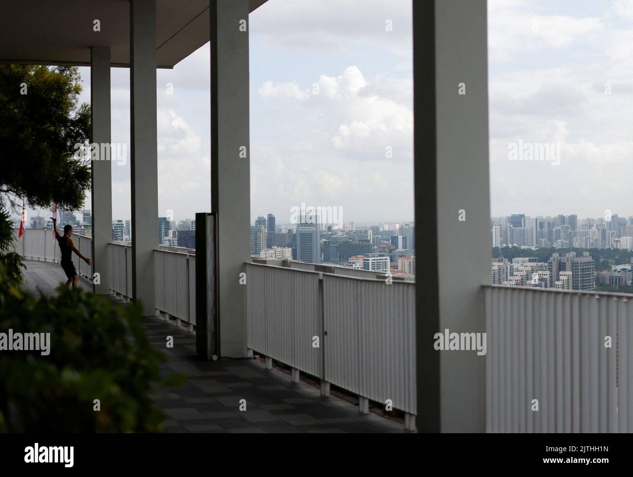 A man exercises on the sky deck of the Pinnacle at Duxton public housing apartment blocks in Singapore August 19, 2022. REUTERS/Edgar Su Stock Photo