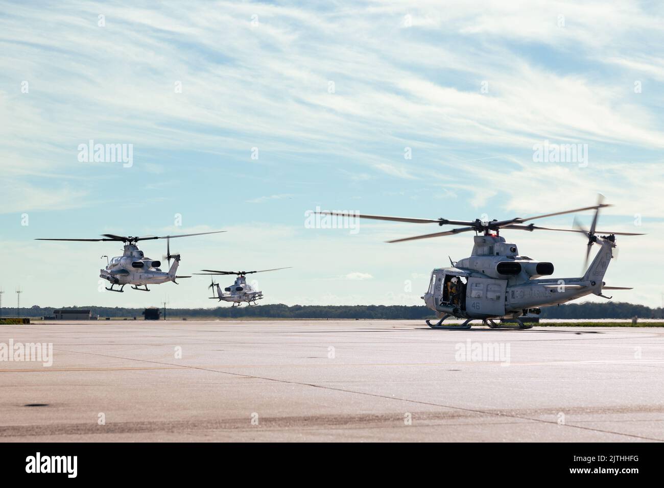 Two U.S. Marine Corps AH-1Z Vipers and one UH-1Y Venom helicopters assigned to Light Attack Helicopter Squadron (HMLA) 773 conduct flight operations at McGuire Air Force Base, New Jersey, Aug. 16, 2022. HMLA-773 launched three UH-1Y Venom and two AH-1Z Viper helicopters from McGuire Air Force Base and embarked them aboard the San Antonio class dock landing ship USS Mesa Verde (LPD 19) in support of an upcoming multinational exercise. (U.S. Marine Corps photo by Cpl. Colton K. Garrett) Stock Photo