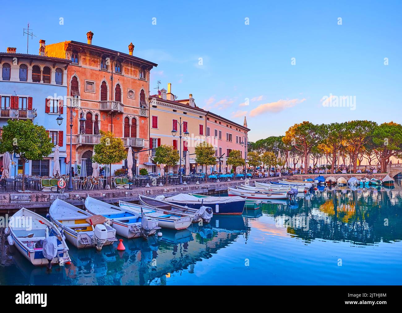 Historic Venetian house amid the colored houses, seen behind the Porto Vecchio (Old Port) of Desenzano del Garda, Lake Garda, Italy Stock Photo