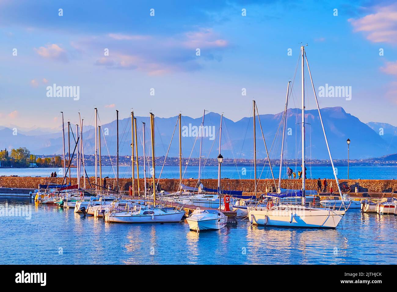 The yacht port on Lake Garda with azure water surface and foggy Garda Prealps in background, Desenzano del Garda, Lombardy, Italy Stock Photo