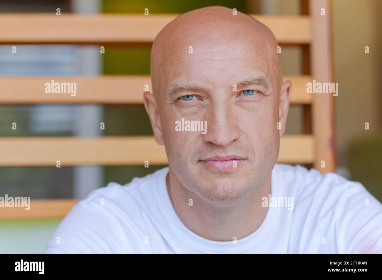 Portrait handsome bald man with blue eyes in a white t shirt with a